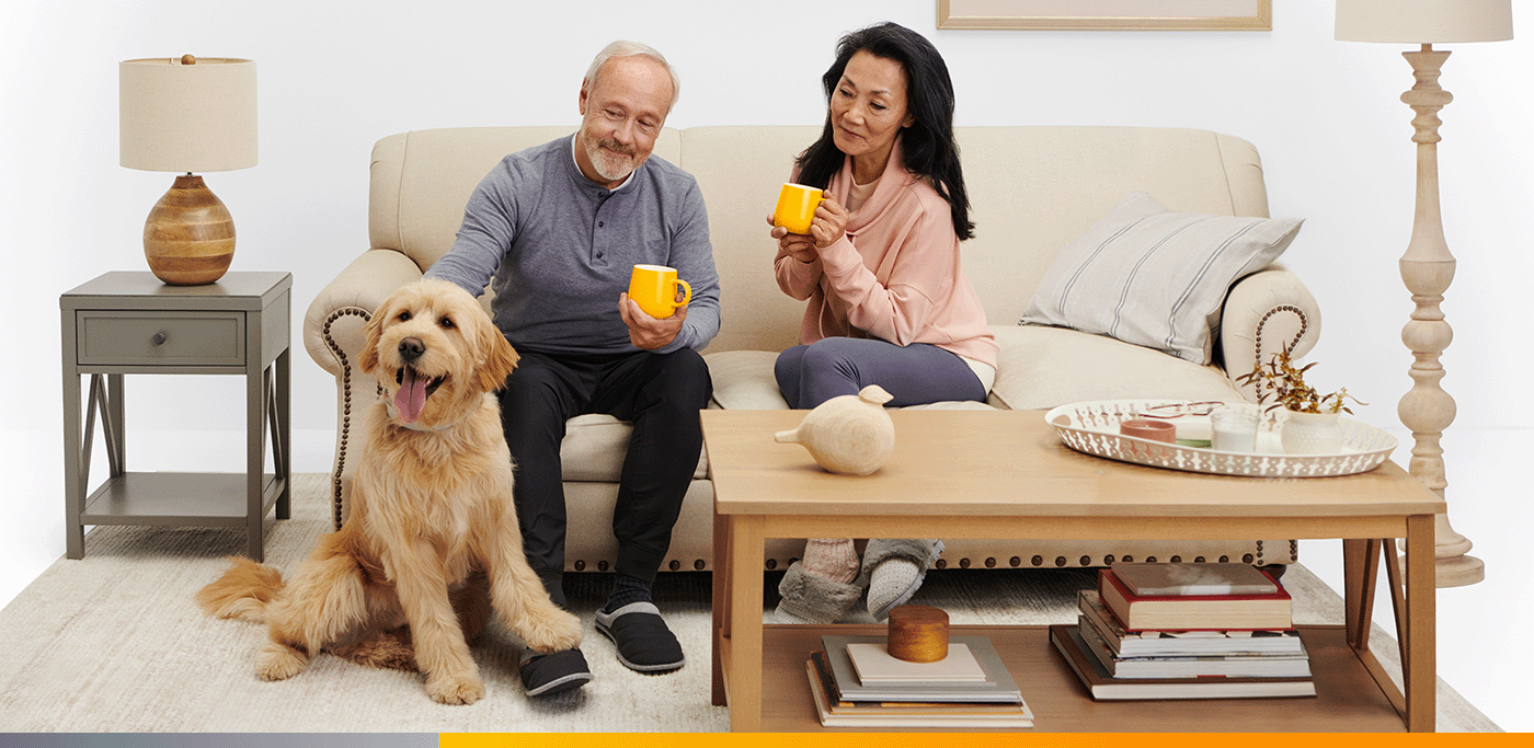 Couple sitting on couch with dog